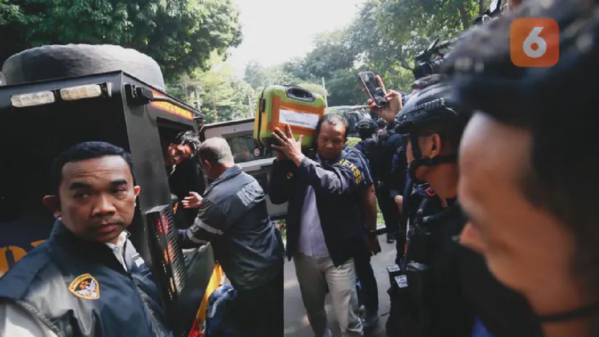 Petugas kepolisian memasukkan barang bukti hasil penggeledahan dari rumah di Sentul terkait